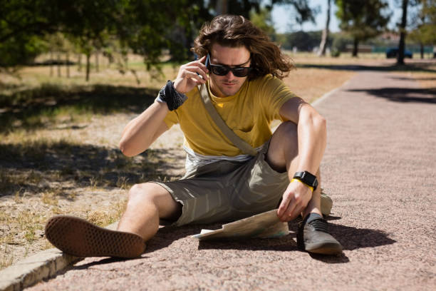 istock Tourist man with map talking on mobile phone 852173696