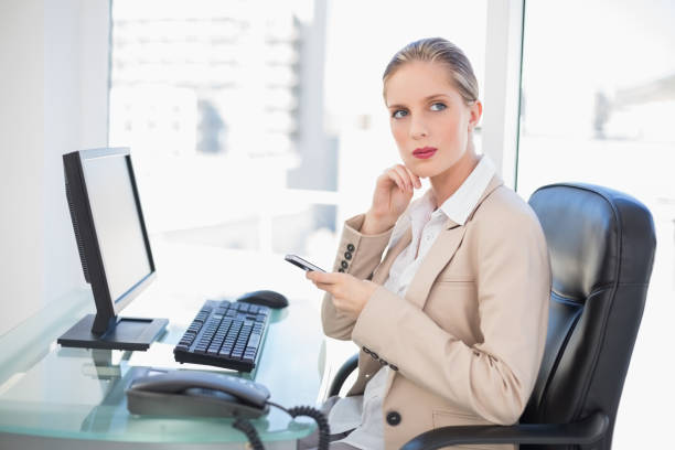 istock Thoughtful blonde businesswoman texting 852178644