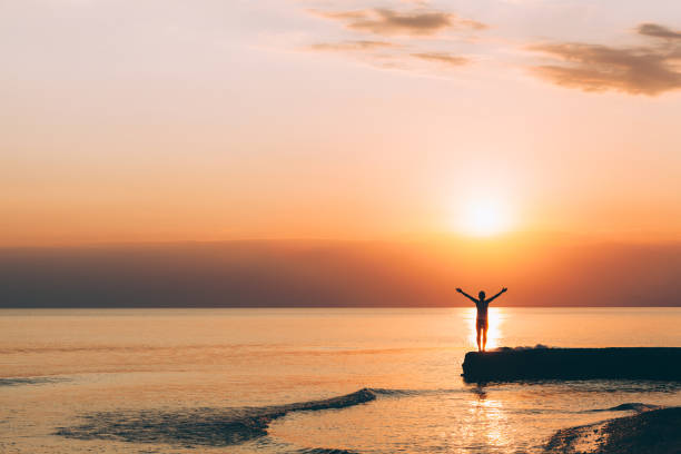 Silhouette of the muslim girl with hidjab during the beautiful sunset  on the beach in Batumi in Georgia