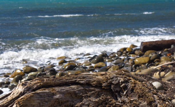 istock rocky sea shore with pebble beach, waves with foam 852191726