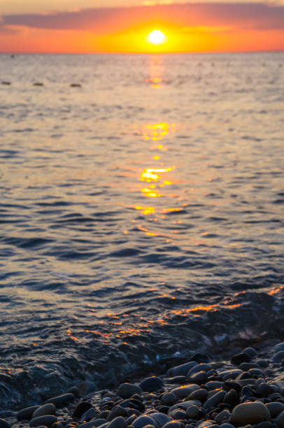 istock Amazing sea sunset on the pebble beach, the sun, waves, clouds 852192568