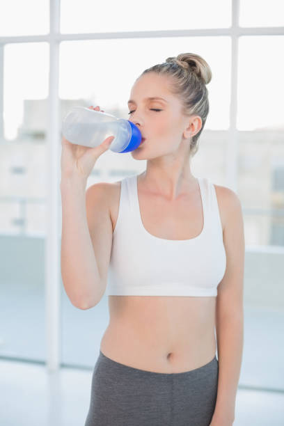istock Peaceful sporty blonde drinking water after exercising 852195292