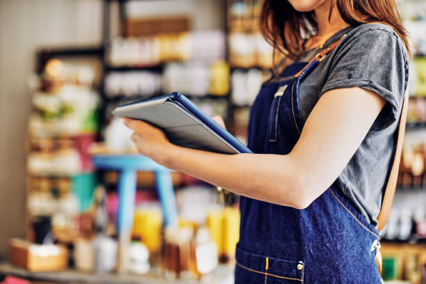 istock Midsection of saleswoman checking inventory with digital tablet 852196312