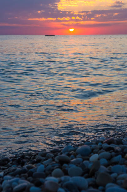 istock Amazing sea sunset on the pebble beach, the sun, waves, clouds 852196704