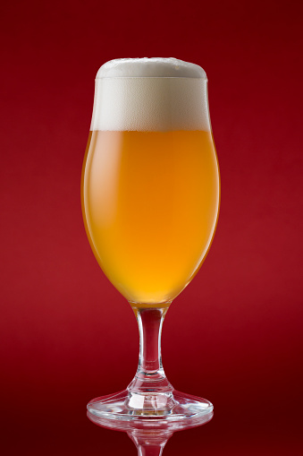 Glass with beer isolated on red