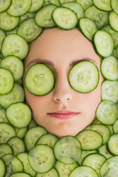 hermosa mujer con máscara facial de pepino rebanadas de cara - facial mask spa treatment cucumber human face fotografías e imágenes de stock