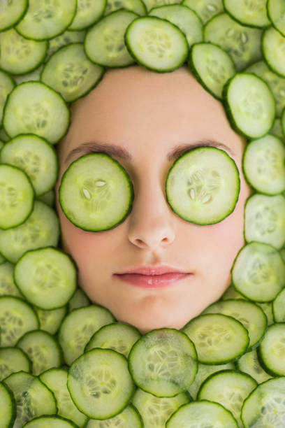 belle femme visage masque de rondelles de concombre sur le visage - cucumber facial mask human face women photos et images de collection