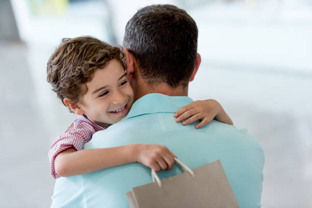 Affectionate son hugging his father at the shopping center