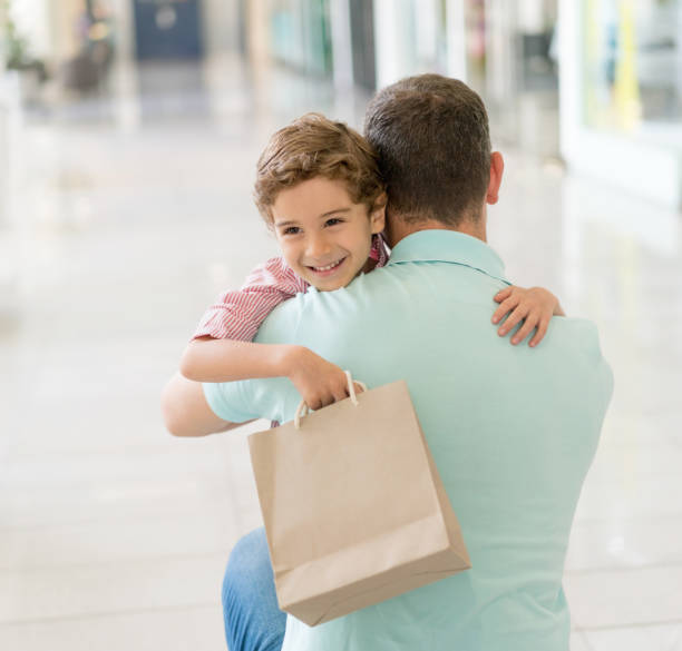 istock Happy son hugging his father at the mall 852208966