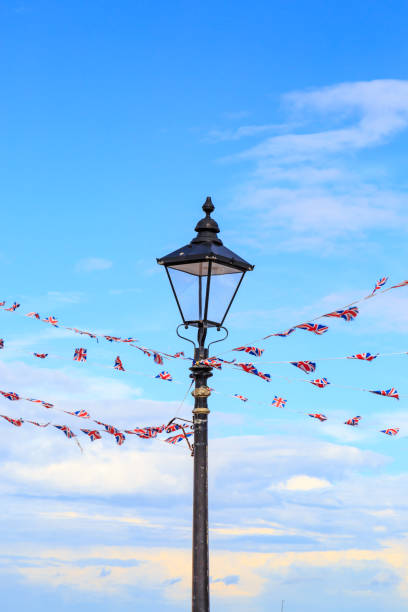 Bunting wrapped around a lamp post A vertical photograph of Union Jack bunting tied around a lamp post and blowing in the wind. herne bay stock pictures, royalty-free photos & images