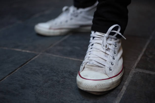 istock Low section of man wearing white canvas shoes 852214404