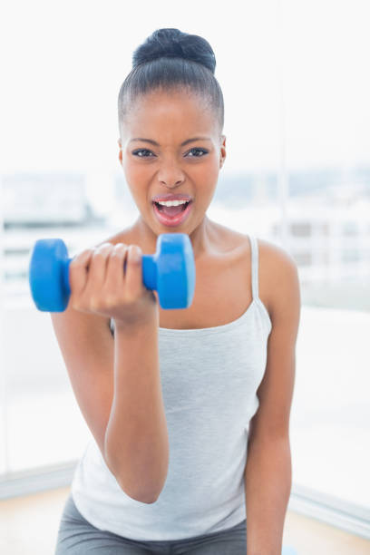 istock Fit woman working out wit h dumbbell while looking at camera 852214702