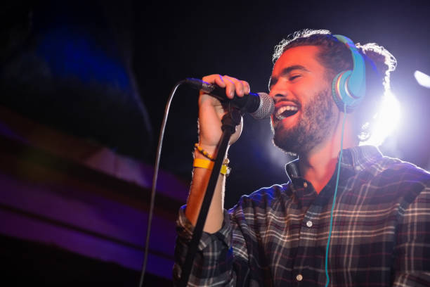 istock Man listening to headphones while singing on microphone 852214850