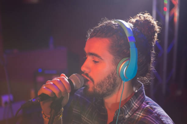 istock Man listening to headphones while singing on microphone 852214868