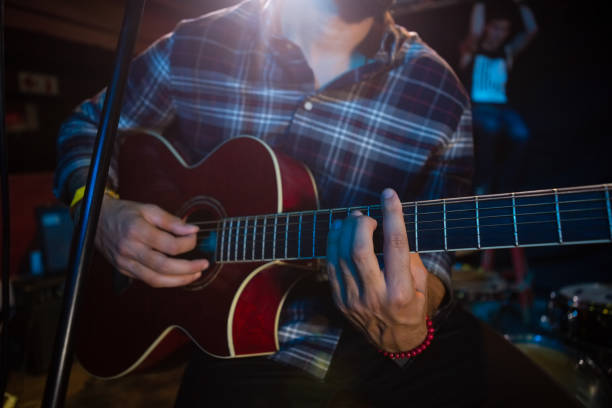 istock Mid section of musician playing guitar on stage 852218196