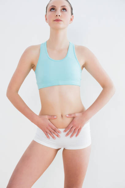istock Serious toned woman standing against wall 852218524