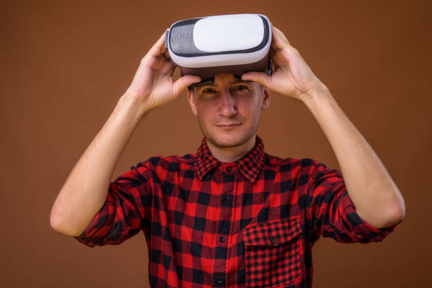 istock Studio shot of man using virtual reality headset against colored background 852224524