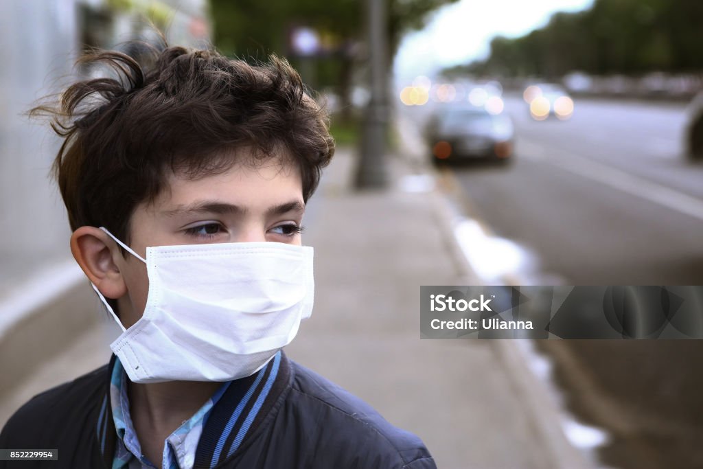 garçon d’adolescent au masque de protection sur la ville de route - Photo de Enfant libre de droits