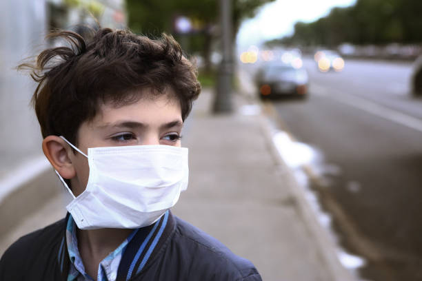 teenager boy in protection mask on the highway city - illness mask pollution car imagens e fotografias de stock