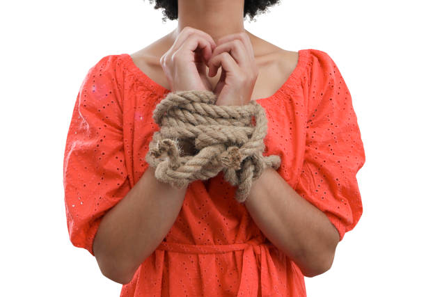 Woman's hands tied with rope on white background