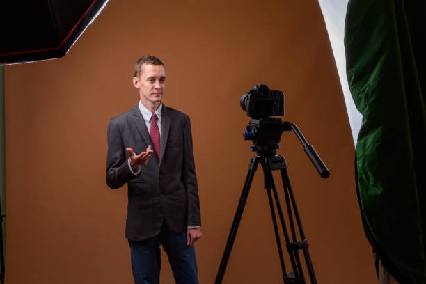 istock Studio shot of young businessman wearing suit while vlogging against colored background 852232588