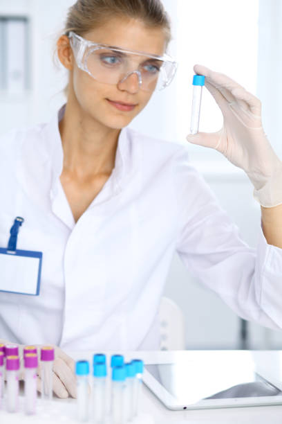 female scientific researcher in laboratory studying substances or blood sample. medicine and science concept - close up medical test exam people imagens e fotografias de stock