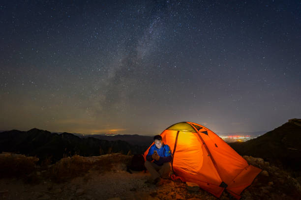 camping tentes chaudes sous la voie lactée, plein air - technology mobile phone people planet photos et images de collection