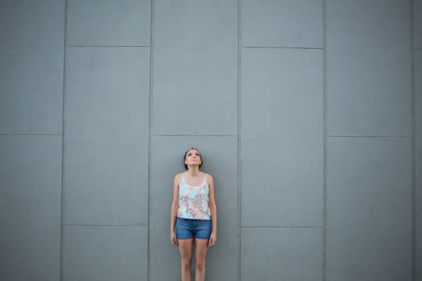 istock Woman standing in front of grey wall 852244340