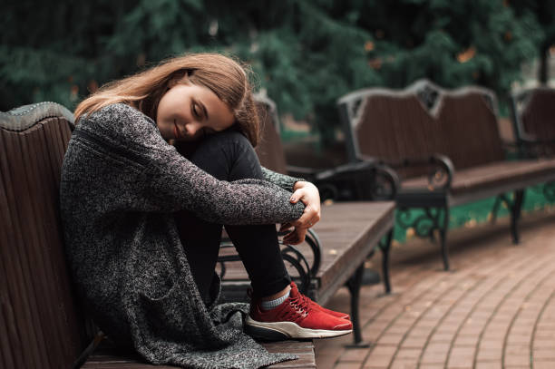 istock Young female sitting on the bench in the park 852251540