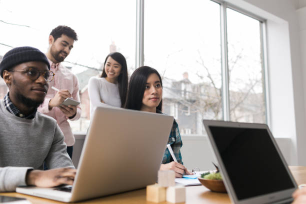 istock Young professionals working on laptops in an office 852252538