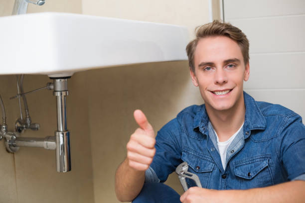 istock Handsome plumber gesturing thumbs up besides washbasin 852255610