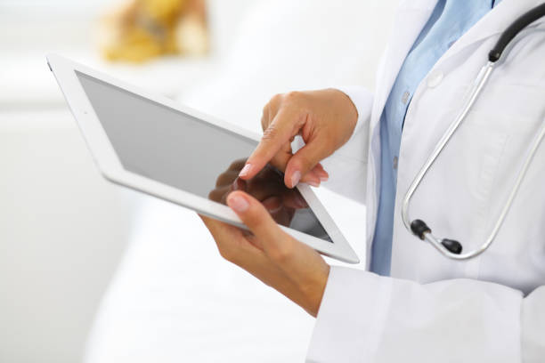 istock Woman doctor using tablet computer while standing straight in hospital 852255764