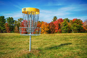 Disc golf hole basket in autumn park