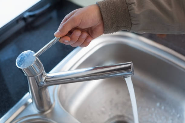 istock Plumbers hand opening a water tap at bathroom 852271050