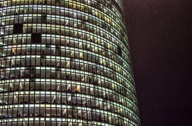 Tall modern business office building with lights on in the night