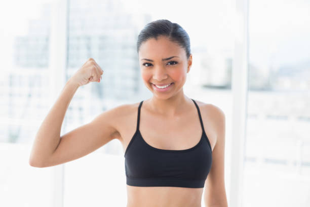 istock Happy dark haired model in sportswear contracting her muscles 852281858