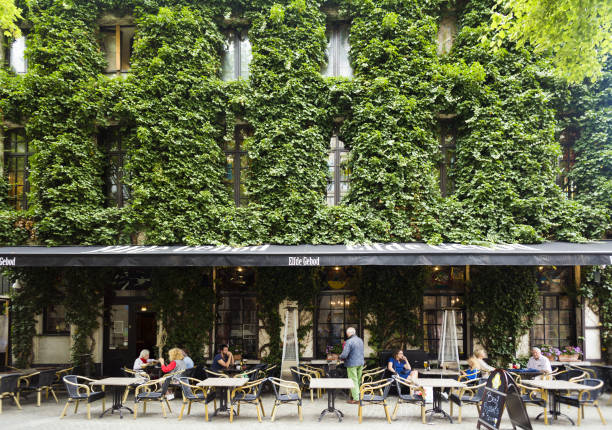 Antwerp, Belgium - August 2, 2017: Sidewalk restaurant and building wall covered with ivy on street Blauwmoezelstraat, Antwerp