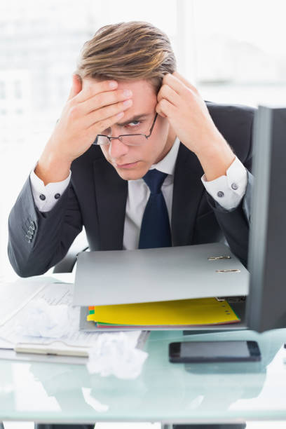 istock Worried businessman with documents at office desk 852282592