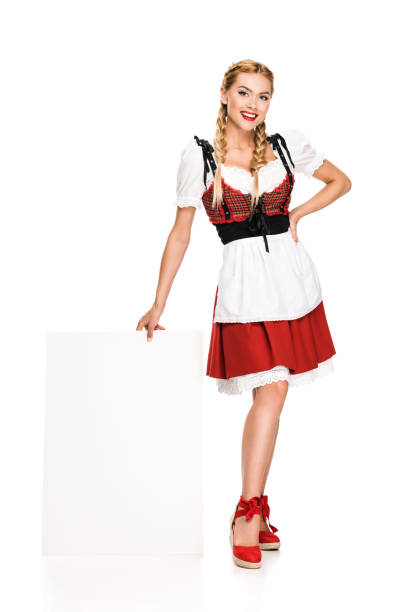happy girl in traditional german costume holding blank board, isolated on white