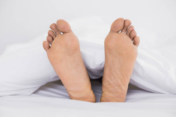 istock Close up of bare feet in bed 852292660