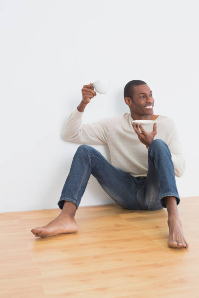 istock Afro man having tea on floor in an empty room 852311372