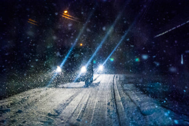 luces de coche de noche tormenta de nieve - faro luz de vehículo fotografías e imágenes de stock