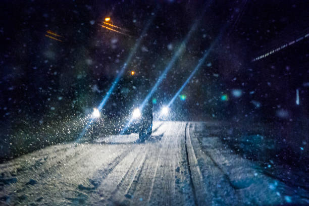 Night Snowstorm Car Lights Car driving during winter snowstorm. Motion blur. headlight stock pictures, royalty-free photos & images