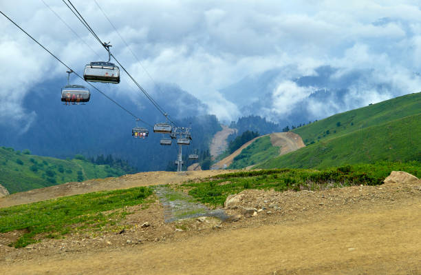 teleférico de la montaña en el cielo de verano azul con nubes dramáticas - overhead cable car summer ski lift scenics fotografías e imágenes de stock