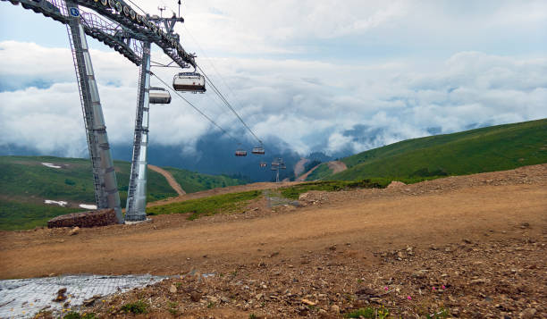 teleférico de la montaña en el cielo de verano azul con nubes dramáticas - overhead cable car summer ski lift scenics fotografías e imágenes de stock