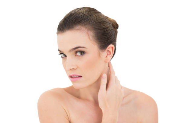 istock Serious woman touching her neck while looking at camera 852313096