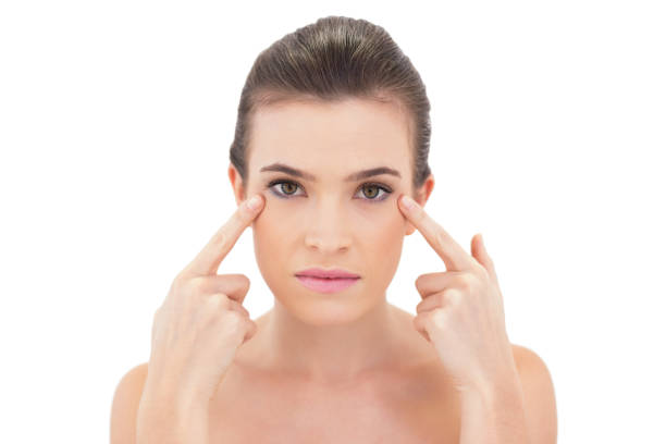 istock Lovely natural brown haired model pointing her eyes with her fingers 852318144