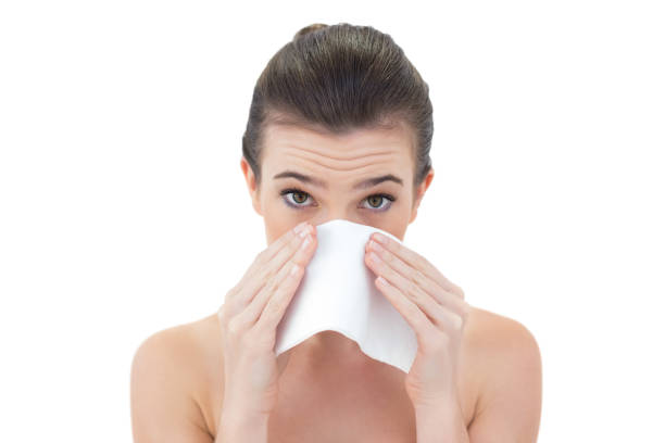 istock Sick natural brown haired model sneezing in a tissue 852324968
