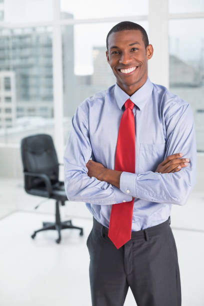 istock Elegant smiling Afro businessman standing in office 852325230