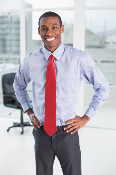 istock Elegant smiling Afro businessman standing in office 852325264